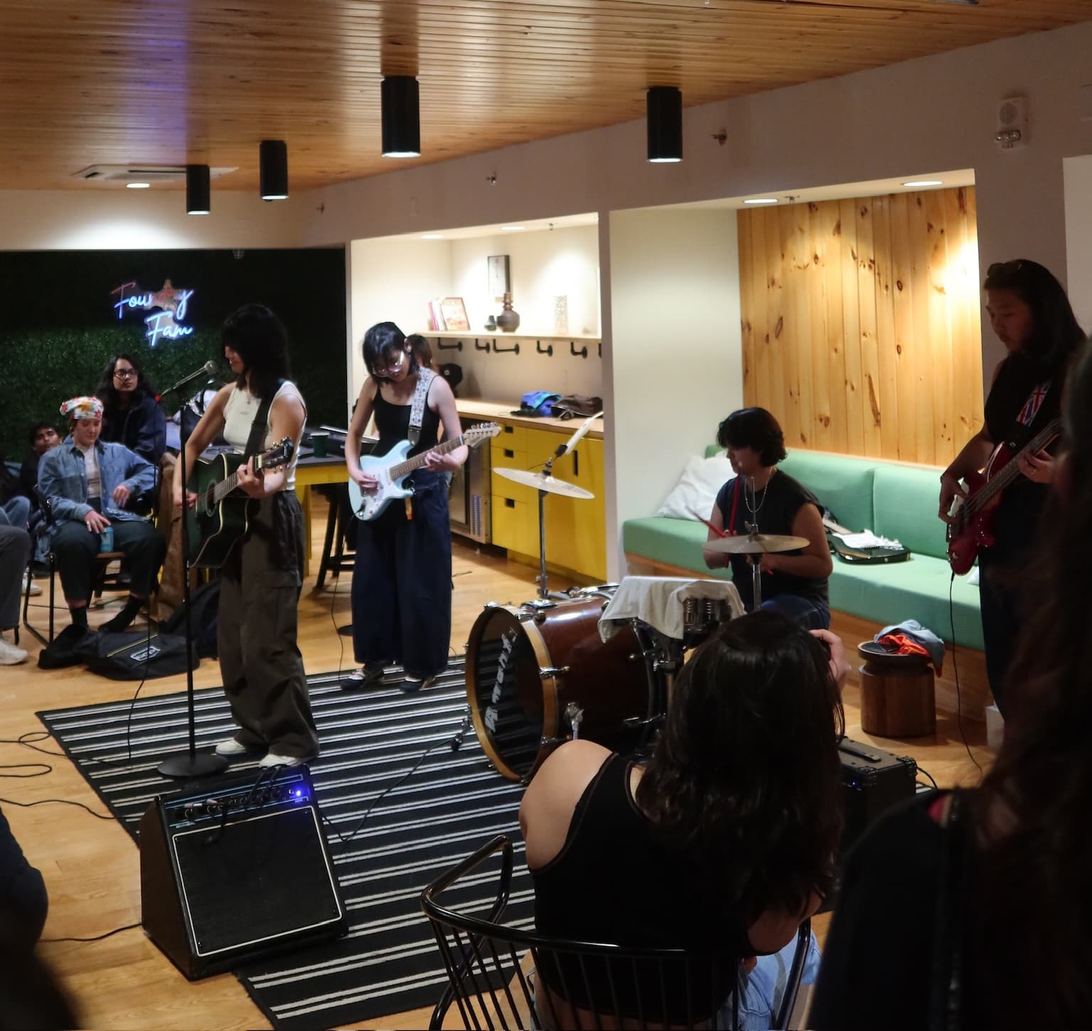 Natasha playing her electric guitar with her bandmates