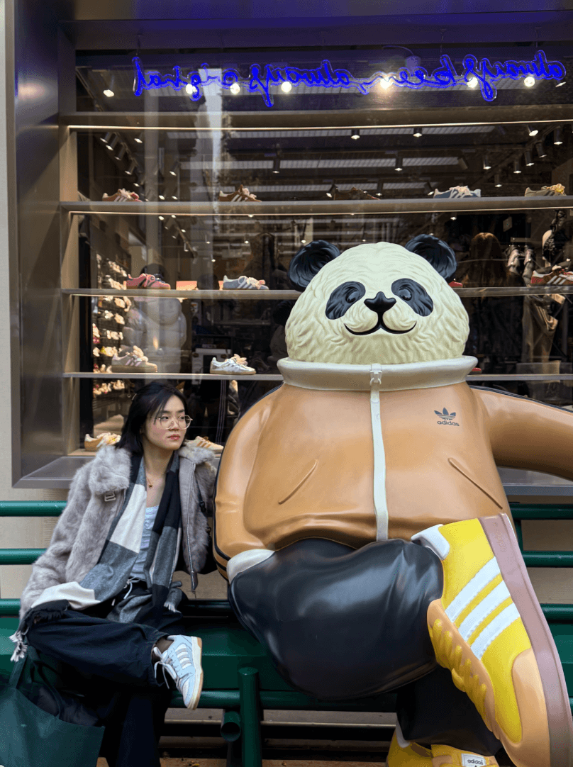 Full-body photo of Natasha with a large panda statue, posing similarly.